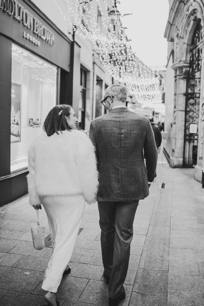 Bride and groom holding hands walking through Dublin city on their wedding day